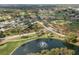 Aerial view of the community showing the lake with fountain, tennis courts, and golf course at 2486 Deer Trail Ln, Spring Hill, FL 34606