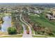 Aerial view showcasing the community's golf course, lake, and manicured landscaping at 2486 Deer Trail Ln, Spring Hill, FL 34606