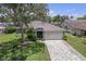 Charming home featuring a two-car garage, brick-paved driveway, and mature landscaping at 2486 Deer Trail Ln, Spring Hill, FL 34606