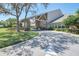 Inviting clubhouse exterior featuring stone accents, a covered entrance, lush landscaping and a well-manicured lawn at 2486 Deer Trail Ln, Spring Hill, FL 34606