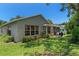 Back exterior view shows home siding, patio, grill, and green lawn at 2486 Deer Trail Ln, Spring Hill, FL 34606