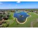 Aerial view of golf course featuring meticulously manicured greens, sand traps, and a picturesque lake at 2486 Deer Trail Ln, Spring Hill, FL 34606