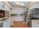 Spacious kitchen with stainless steel appliances, white cabinets, stylish countertops, and hardwood flooring at 2486 Deer Trail Ln, Spring Hill, FL 34606