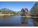 Scenic lake view with a charming wooden gazebo and surrounding lush greenery on a clear, sunny day at 2486 Deer Trail Ln, Spring Hill, FL 34606