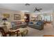 Cozy living room featuring two sofas, a ceiling fan, and a view of the dining area at 2486 Deer Trail Ln, Spring Hill, FL 34606