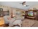 Inviting living room with ceiling fans, a tropical theme, ample seating, and a large area rug at 2486 Deer Trail Ln, Spring Hill, FL 34606