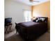 Bedroom featuring a queen-sized bed with dark brown finishings and ceiling fan at 2542 Sandy Hill Ct, Holiday, FL 34691