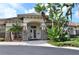 Inviting clubhouse entrance with stone accents and lush tropical landscaping, creating a welcoming atmosphere at 2542 Sandy Hill Ct, Holiday, FL 34691