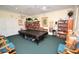 Inviting game room with a pool table, bookshelves, and comfortable seating area at 2542 Sandy Hill Ct, Holiday, FL 34691