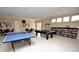 Fun game room offering a ping pong table, billiard table, and reading nook for social and recreational activities at 2542 Sandy Hill Ct, Holiday, FL 34691