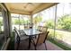 Screened lanai with a table and chairs, offering a relaxing outdoor space at 2542 Sandy Hill Ct, Holiday, FL 34691