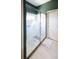 Modern shower with glass doors, decorative etching, and tiled floor at 2542 Sandy Hill Ct, Holiday, FL 34691