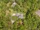 Aerial shot of a home with stone patio surrounded by lush greenery, offering privacy and a natural landscape at 27091 Country Oak Dr, Brooksville, FL 34602