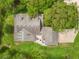 An aerial perspective showcases a home with a brick patio, highlighting outdoor living space surrounded by green grass at 27091 Country Oak Dr, Brooksville, FL 34602