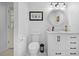 Cozy bathroom with tile floors, white cabinets, and a round mirror at 27091 Country Oak Dr, Brooksville, FL 34602