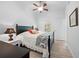 Bright bedroom featuring a ceiling fan, light wood floors, and a black bed frame with stylish bedding at 27091 Country Oak Dr, Brooksville, FL 34602