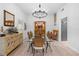 Bright dining room with a glass-top table, wicker chairs, a modern chandelier, and stylish decor at 27091 Country Oak Dr, Brooksville, FL 34602