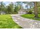 A long driveway leads to a three-car garage on a landscaped lot at 27091 Country Oak Dr, Brooksville, FL 34602