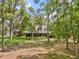 Two-story home set amongst large shade trees with verdant lawn and greenery at 27091 Country Oak Dr, Brooksville, FL 34602