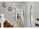 Hallway and foyer displaying striped wallpaper, light wood floors, and a view into other rooms of the home at 27091 Country Oak Dr, Brooksville, FL 34602