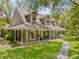 Inviting two-story home featuring a covered porch with rocking chairs and a stone pathway at 27091 Country Oak Dr, Brooksville, FL 34602