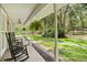 Relaxing covered porch featuring rocking chairs, fern hangings and a view of the property at 27091 Country Oak Dr, Brooksville, FL 34602