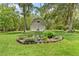 View of the garage with a well-manicured lawn and garden at 27091 Country Oak Dr, Brooksville, FL 34602