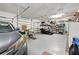Spacious three car garage with a gray car parked on the left and a golf cart in the center at 27091 Country Oak Dr, Brooksville, FL 34602