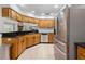 Spacious kitchen featuring wood cabinets, granite countertops, stainless steel appliances, and light hardwood flooring at 27091 Country Oak Dr, Brooksville, FL 34602