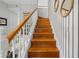 A homey staircase with hardwood steps and white railings, illuminated by natural light at 27091 Country Oak Dr, Brooksville, FL 34602
