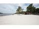 Expansive white sand beach featuring palm trees and a covered picnic area at 2930 Plantain Dr, Holiday, FL 34691
