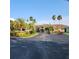 A clubhouse with a parking area and nicely landscaped grounds with various palm trees at 2930 Plantain Dr, Holiday, FL 34691