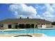A community pool with lounge seating and a pool house at the edge of the water at 2930 Plantain Dr, Holiday, FL 34691