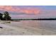 Scenic view of a calm beach at sunset with a pink and purple hued sky at 2930 Plantain Dr, Holiday, FL 34691