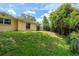 Landscaped backyard with a gentle slope leading to a tree lined fence at 3140 Bahia Ave, Holiday, FL 34690