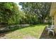 Private backyard with mature trees, a lush lawn, and a view of the natural landscape at 3140 Bahia Ave, Holiday, FL 34690