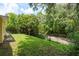 A view of the backyard with green grass leading up to a tree-lined creek at 3140 Bahia Ave, Holiday, FL 34690