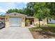Charming yellow house with a well-maintained front yard and a white garage door at 3140 Bahia Ave, Holiday, FL 34690