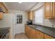 Functional kitchen features wood cabinets, a stainless steel sink, and a door to the backyard at 3140 Bahia Ave, Holiday, FL 34690