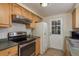Functional kitchen features wood cabinets, stainless steel appliances, and a door to the backyard at 3140 Bahia Ave, Holiday, FL 34690