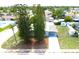 Aerial shot of a house with a grass yard, tall pines, and wide driveway at 3151 Wellington Dr, Holiday, FL 34691