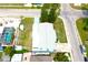 Birds-eye-view of home with roof, overgrown yard, and enclosed pool nearby at 3151 Wellington Dr, Holiday, FL 34691