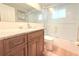 Modern bathroom with a wood vanity, stone countertop, and a glass-enclosed shower at 3151 Wellington Dr, Holiday, FL 34691