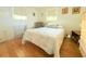 Bright bedroom featuring wood floors, a comfortable bed, and natural light from the window at 3151 Wellington Dr, Holiday, FL 34691