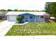 A high-angle view of a cozy home with lush landscaping, a driveway and an attached garage at 3151 Wellington Dr, Holiday, FL 34691