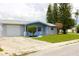 Single-story home featuring an attached garage, established landscaping, and a welcoming entryway at 3151 Wellington Dr, Holiday, FL 34691
