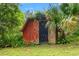 Rustic red barn on property with an open doorway and mature surrounding trees at 3270 Endsley Rd, Brooksville, FL 34604