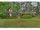 Charming home with a cozy front porch, beautiful landscaping, and a lush green lawn at 3270 Endsley Rd, Brooksville, FL 34604