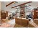 Bright living room with high ceilings, exposed wood beams, and a brick fireplace at 3270 Endsley Rd, Brooksville, FL 34604
