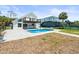 Backyard view of pool, patio, black railinged deck, and fenced yard at 4104 Pine Dale Ct, Hernando Beach, FL 34607